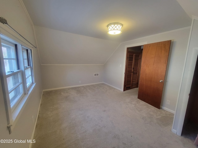 bonus room featuring light colored carpet and vaulted ceiling