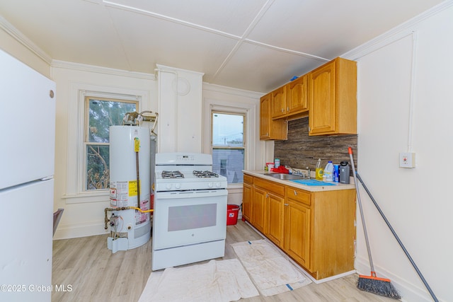 kitchen featuring sink, gas water heater, white appliances, and light wood-type flooring