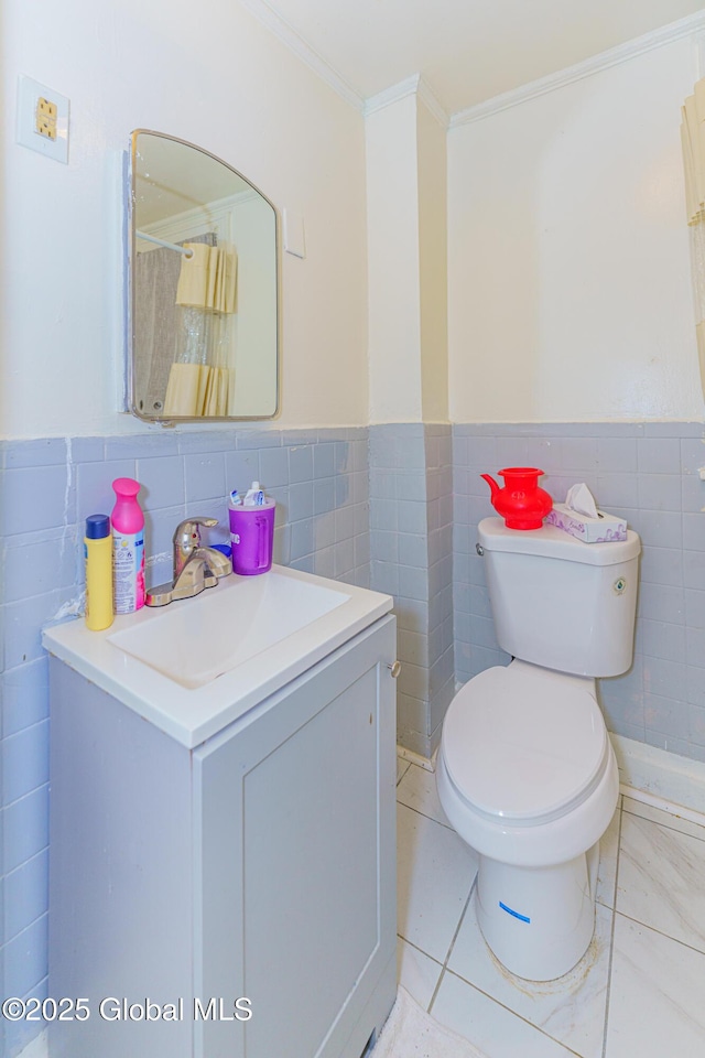 bathroom with tile patterned flooring, vanity, tile walls, and toilet