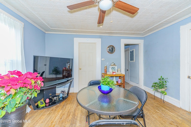 dining space featuring ceiling fan, wood-type flooring, and ornamental molding