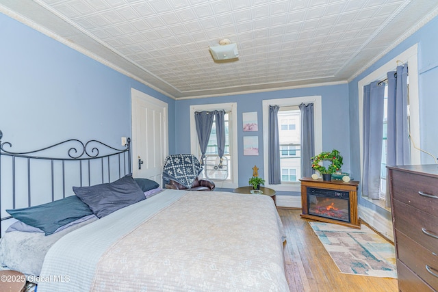 bedroom featuring hardwood / wood-style flooring and crown molding