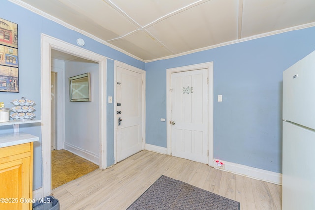 foyer featuring crown molding and light hardwood / wood-style flooring