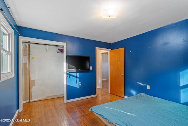 unfurnished bedroom with a closet and wood-type flooring