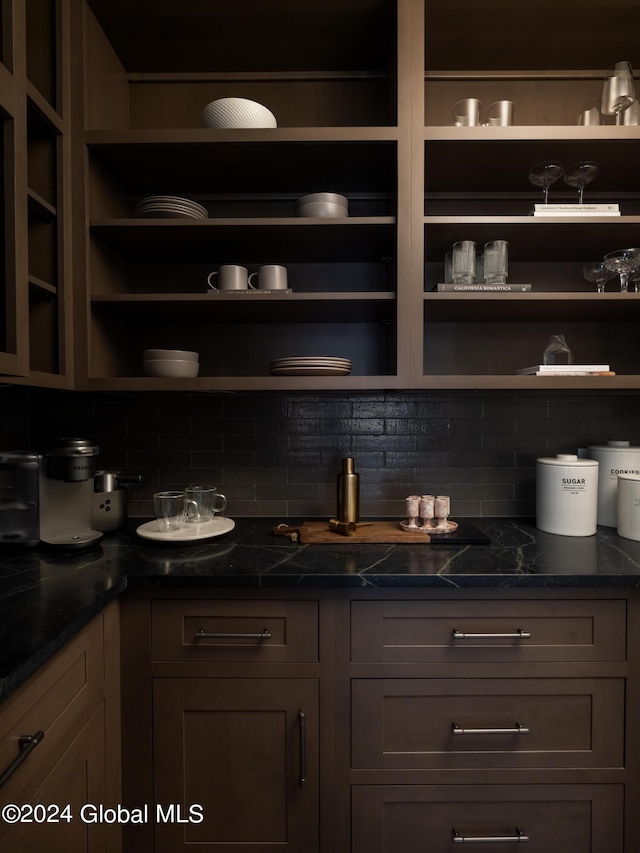 bar featuring tasteful backsplash and dark stone countertops