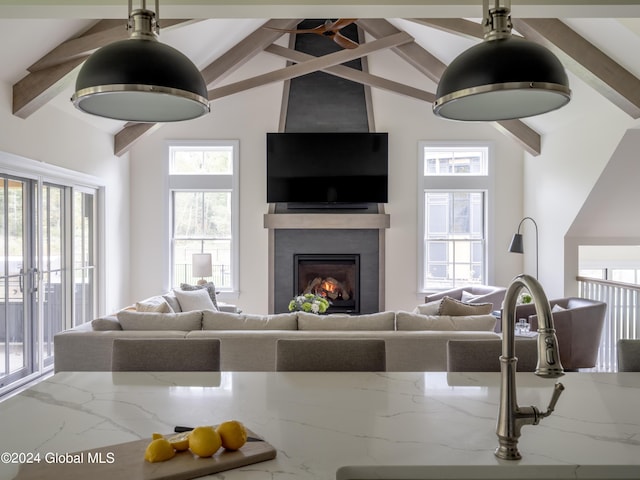 living room with beamed ceiling and high vaulted ceiling