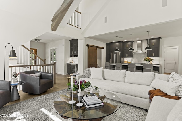 living room featuring a barn door, beamed ceiling, dark wood-type flooring, and high vaulted ceiling