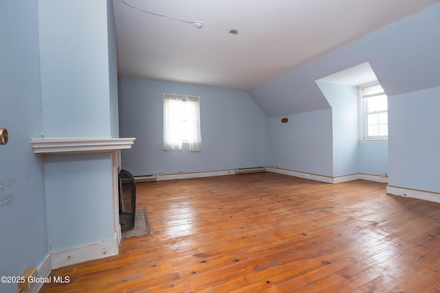 additional living space with vaulted ceiling and light wood-type flooring