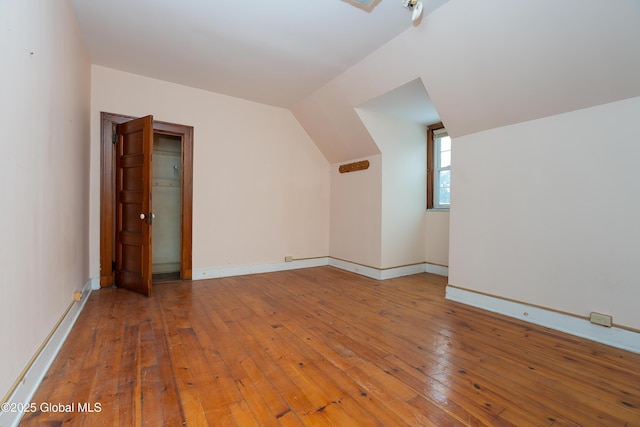 additional living space featuring hardwood / wood-style floors and lofted ceiling