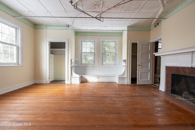 unfurnished living room with hardwood / wood-style floors and a drop ceiling