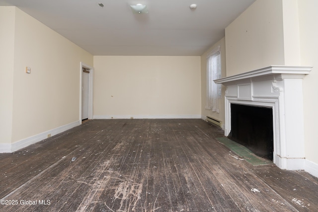 unfurnished living room with dark wood-type flooring and a baseboard heating unit