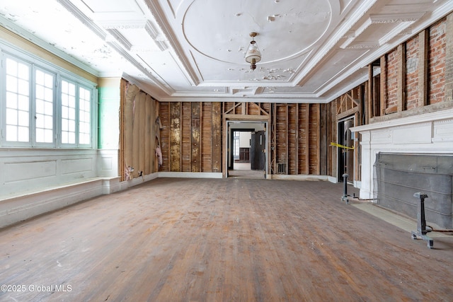 unfurnished living room with a tray ceiling, wood-type flooring, and ornamental molding