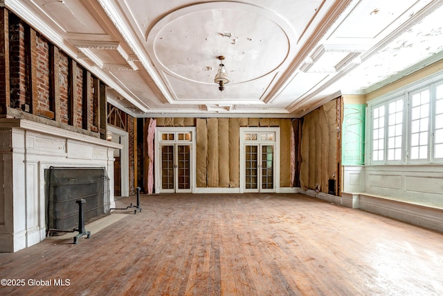 unfurnished living room featuring wood-type flooring and ornamental molding