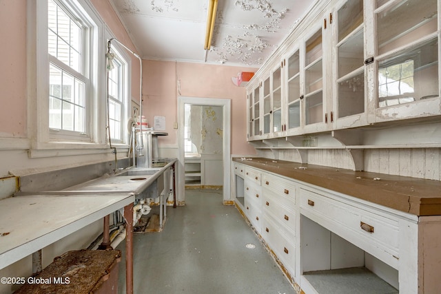 kitchen with white cabinets and concrete flooring