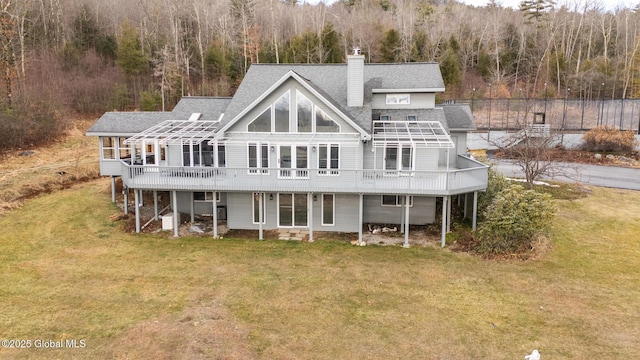 rear view of house with a yard and a deck