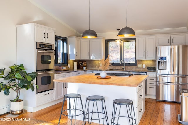 kitchen featuring wood counters, a kitchen island, white cabinetry, and appliances with stainless steel finishes