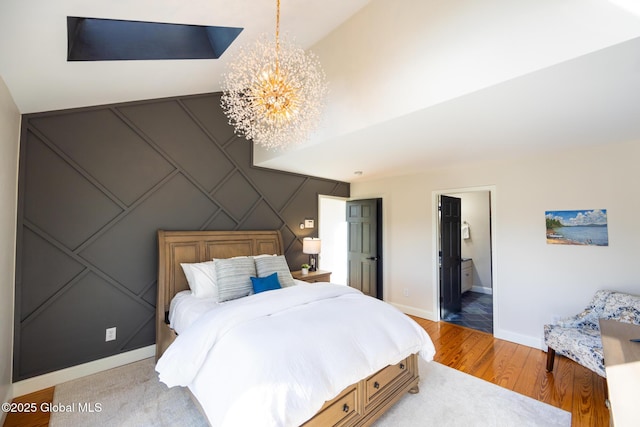 bedroom featuring connected bathroom, light hardwood / wood-style flooring, and a notable chandelier