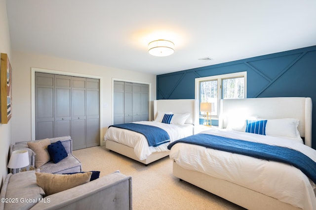 carpeted bedroom featuring two closets