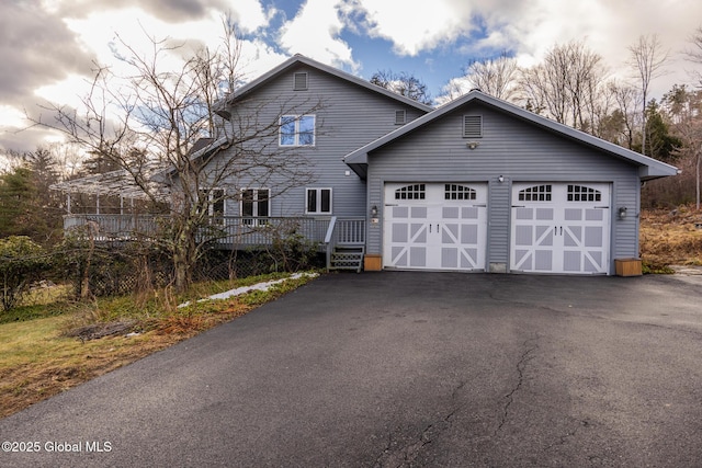 view of front facade featuring a garage and a wooden deck