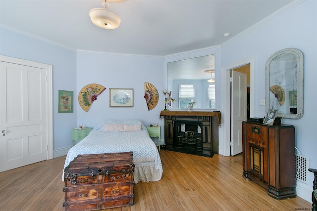 bedroom with light hardwood / wood-style floors and ornamental molding