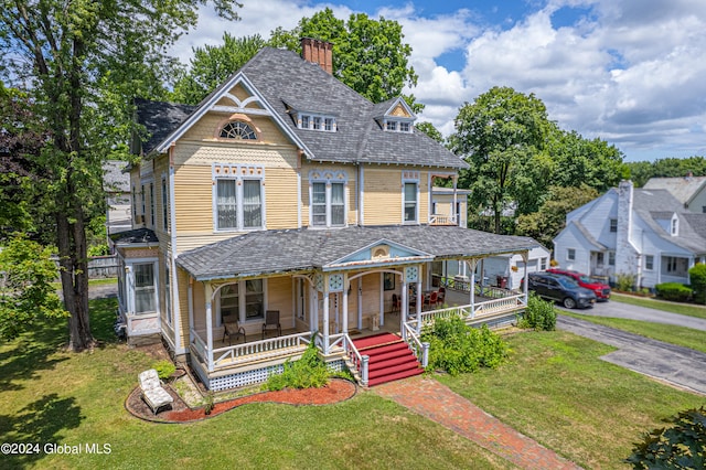 victorian home with a porch and a front lawn