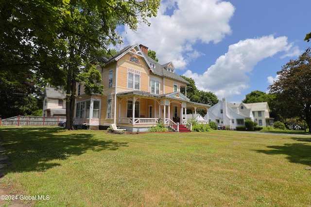 victorian-style house with a front yard and a porch