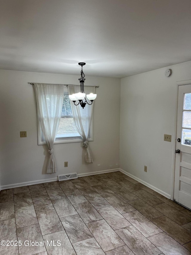 unfurnished dining area with an inviting chandelier