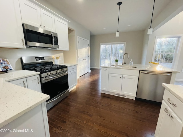 kitchen with sink, decorative light fixtures, white cabinetry, and appliances with stainless steel finishes