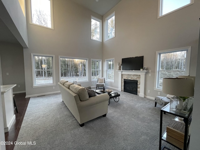 carpeted living room featuring a high ceiling and a fireplace