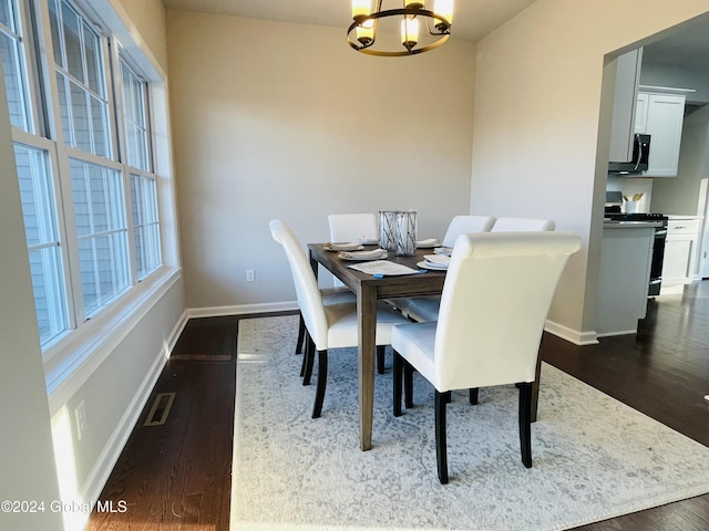 dining area with a chandelier and dark hardwood / wood-style floors