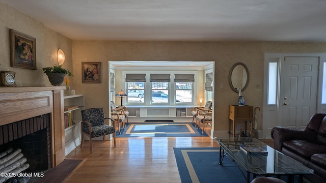 living area with wood finished floors and a fireplace with flush hearth