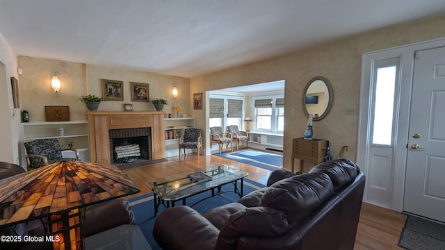 living room featuring a fireplace with flush hearth and wood finished floors