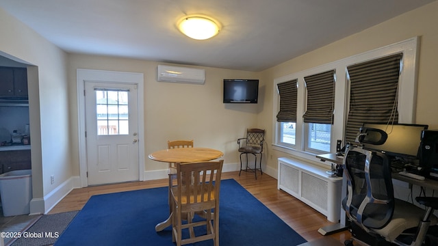 interior space featuring an AC wall unit, a healthy amount of sunlight, and wood finished floors