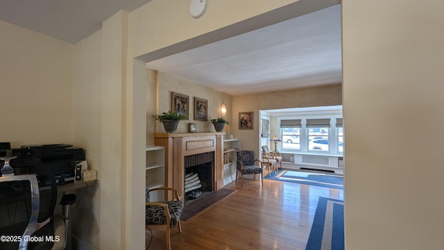 living room with a fireplace with flush hearth and wood finished floors