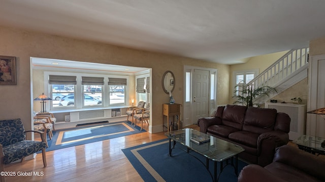 living room featuring stairway, wood finished floors, and baseboards