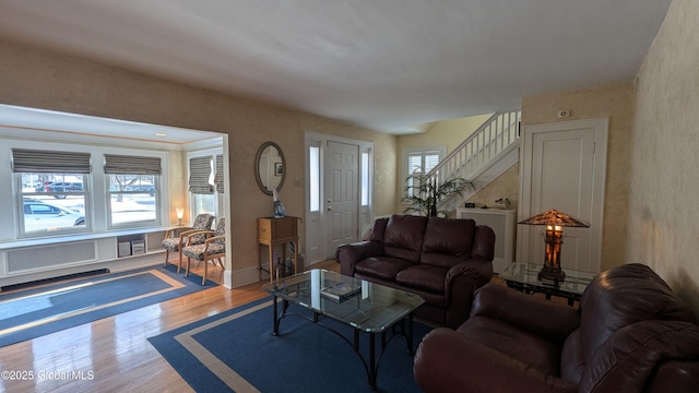 living area featuring stairway, baseboards, and wood finished floors