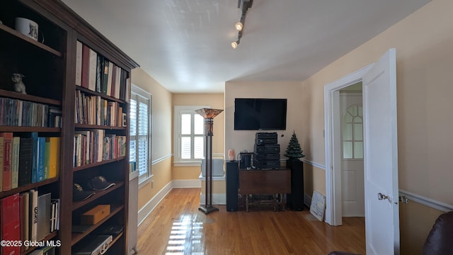 office space with track lighting, baseboards, and wood finished floors