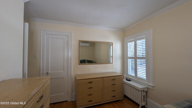 bedroom with ornamental molding, baseboards, dark wood finished floors, and radiator heating unit