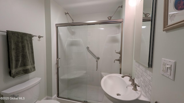 full bath with a sink, a shower stall, and toilet