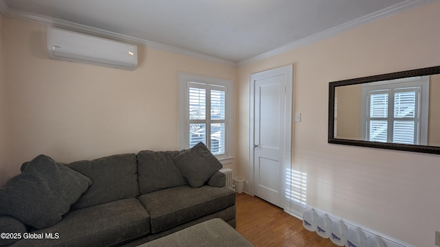 living room with a wall unit AC, light wood finished floors, and ornamental molding