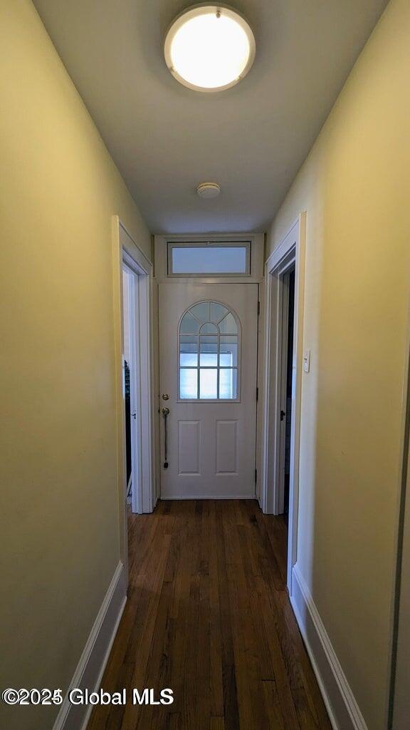 doorway to outside with dark wood-style flooring and baseboards