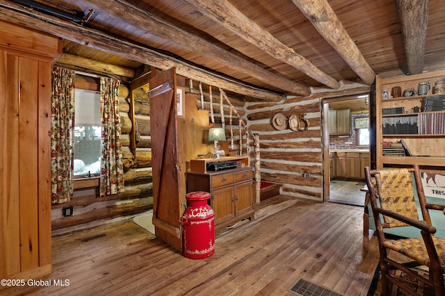 interior space with hardwood / wood-style flooring, beam ceiling, wooden ceiling, and rustic walls