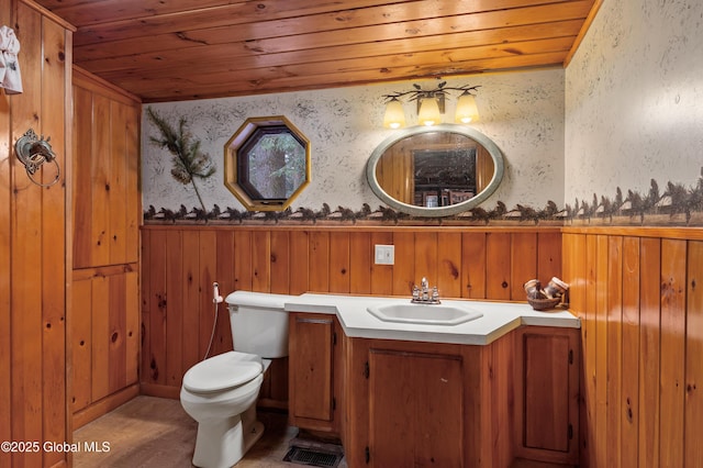 bathroom featuring vanity, wood walls, toilet, and wood ceiling