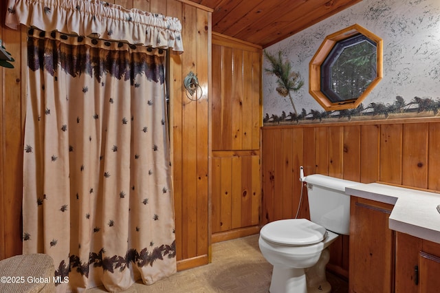 bathroom featuring parquet flooring, vanity, wooden walls, wooden ceiling, and toilet