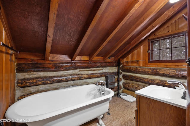 bathroom featuring wood walls, wood-type flooring, lofted ceiling, a bathtub, and vanity