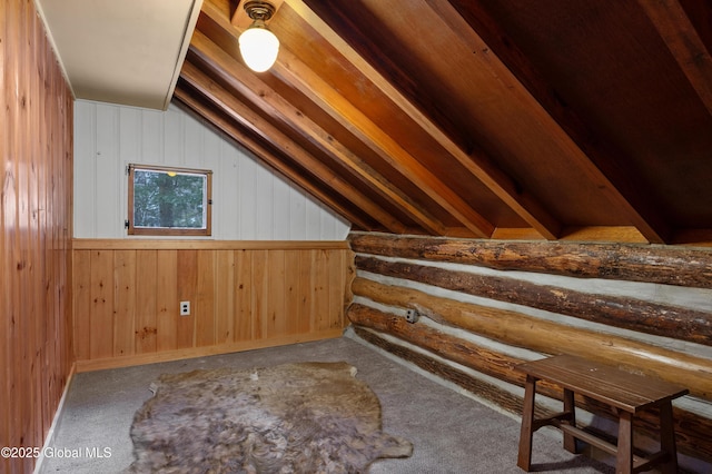 bonus room with carpet floors, vaulted ceiling, and wood walls