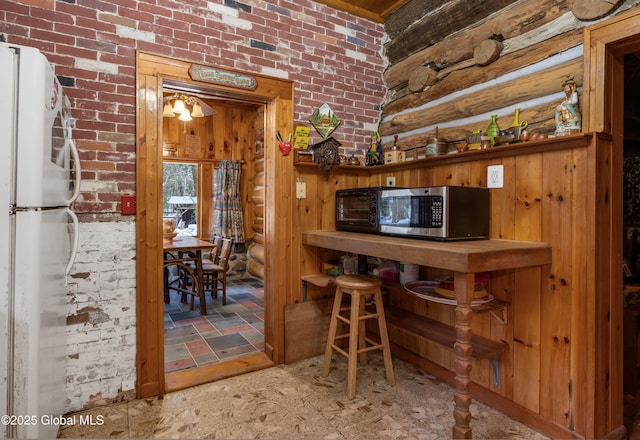 bar with white refrigerator and brick wall