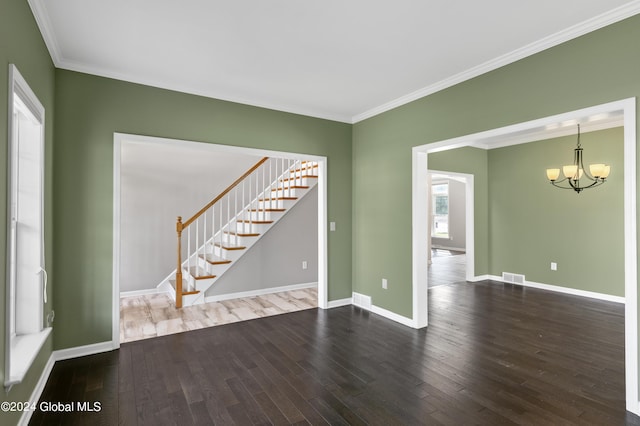 spare room with dark hardwood / wood-style floors, crown molding, and a chandelier