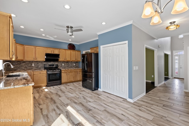 kitchen with stainless steel gas stove, sink, hanging light fixtures, black refrigerator with ice dispenser, and decorative backsplash