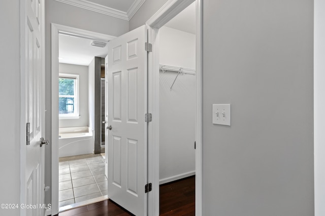 corridor with dark tile patterned floors and crown molding