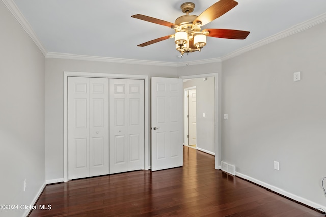 unfurnished bedroom featuring dark hardwood / wood-style flooring, a closet, ornamental molding, and ceiling fan